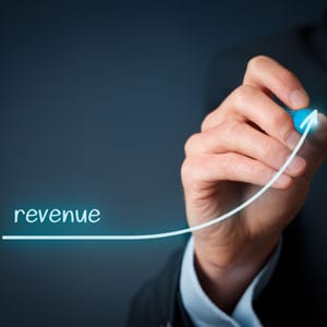 A businessman's hand drawing a revenue line - Big Catch Consulting